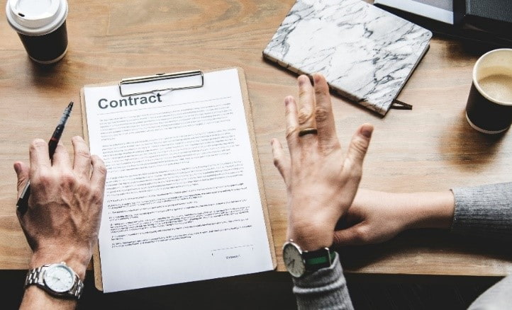 Contract paper on desk between two people