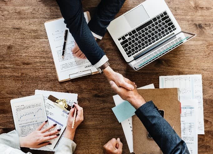 Business people shaking hands over desk