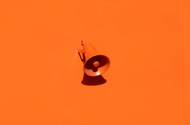 Megaphone installed on orange wall